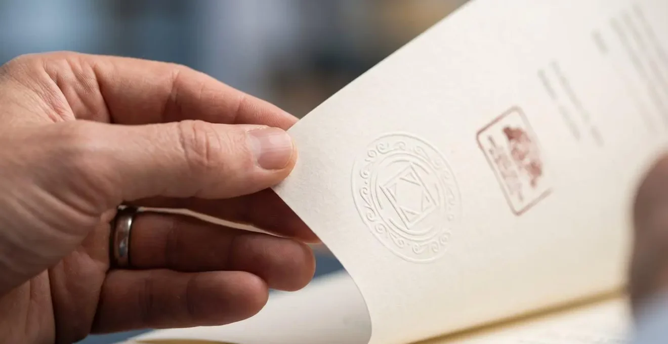 Gros plan sur des mains tenant des documents avec certificats officiels sur un bureau